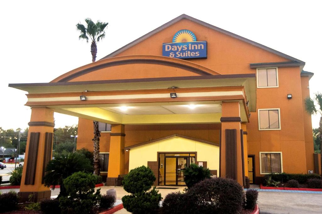 a day inn and suites building with a sign on it at Days Inn & Suites by Wyndham Houston North/Aldine in Houston