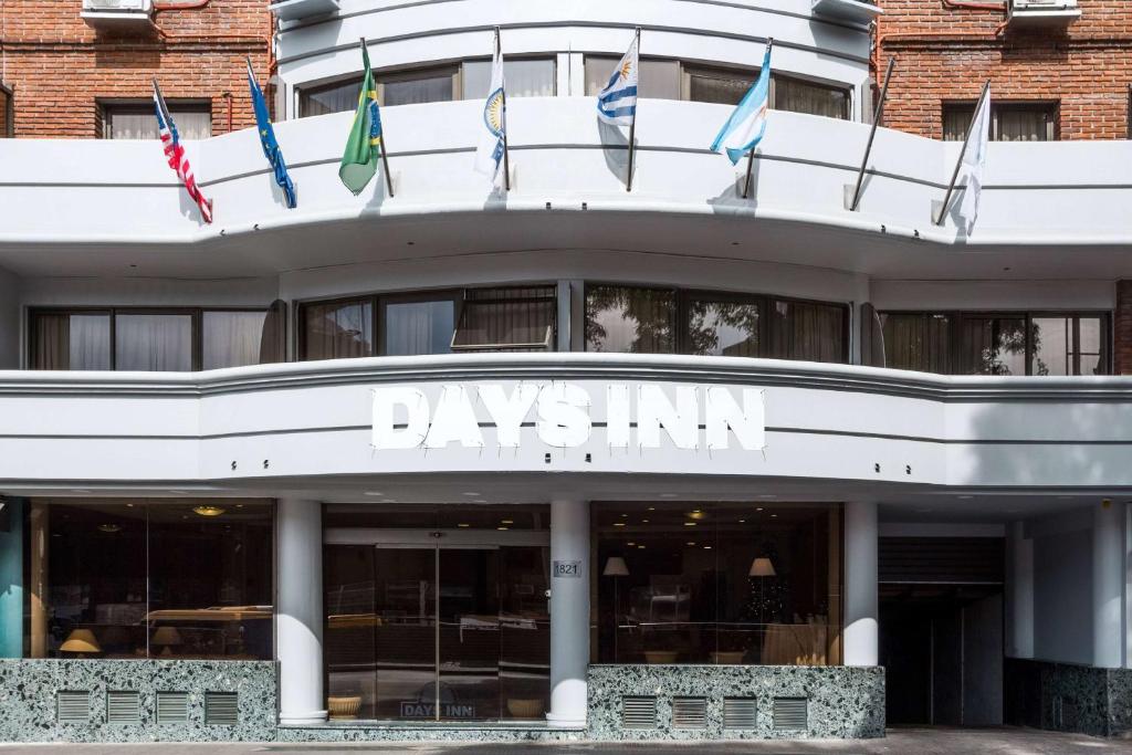 um edifício com bandeiras na frente em Days Inn by Wyndham Montevideo em Montevidéu