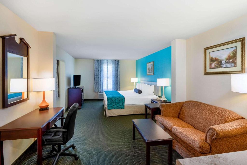 ein Hotelzimmer mit einem Sofa und einem Bett in der Unterkunft Howard Johnson by Wyndham Houma in Houma