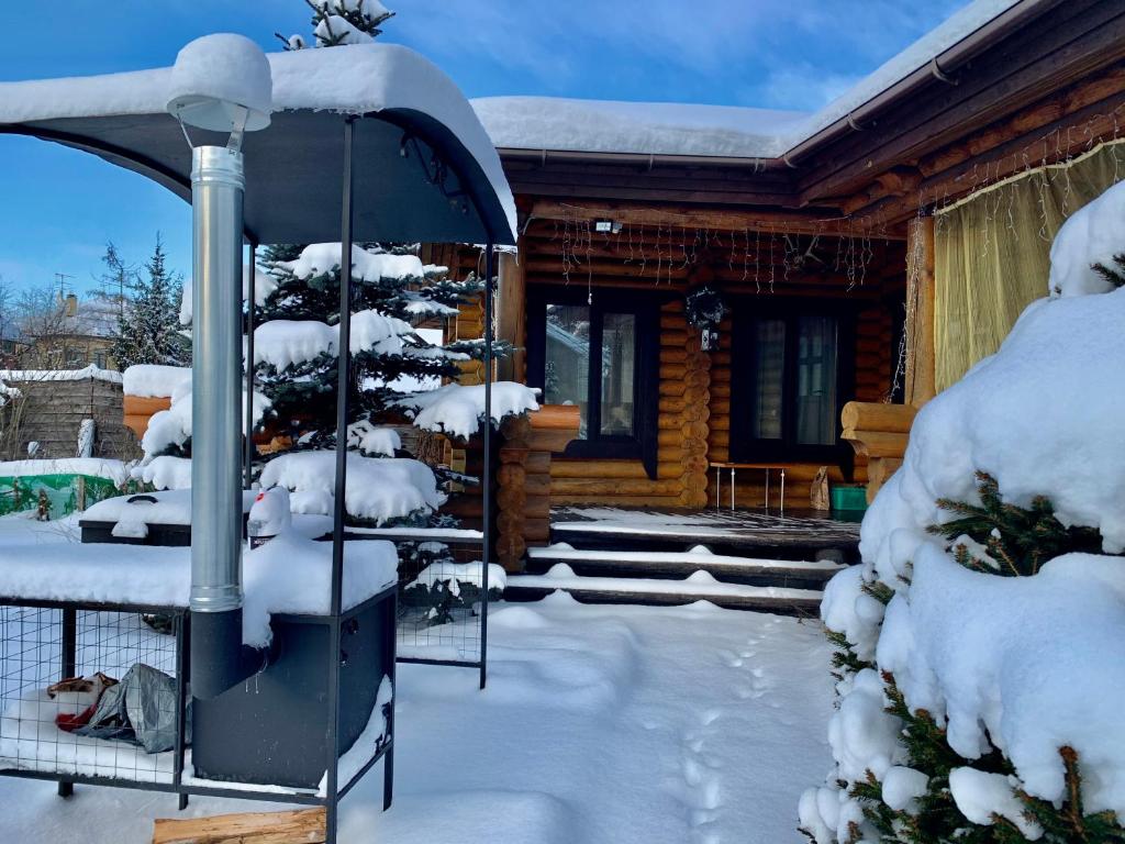 プーシキンにあるDomik na Berezovoy 6の雪上のクリスマスツリーの丸太小屋