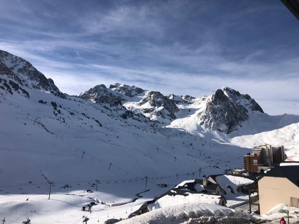 una cordillera cubierta de nieve con una ciudad en primer plano en Duplex 8 couchages, au pied des pistes de la Mongie, en La Mongie