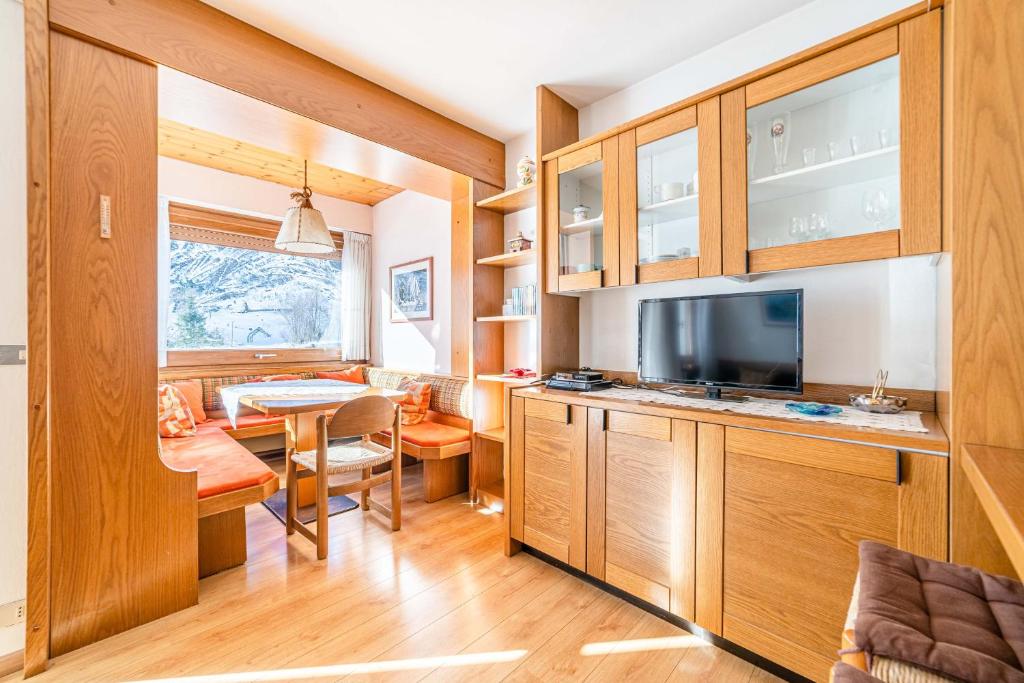 卡普里萊的住宿－Appartamento Civetta，一间带木制橱柜的厨房和一间用餐室