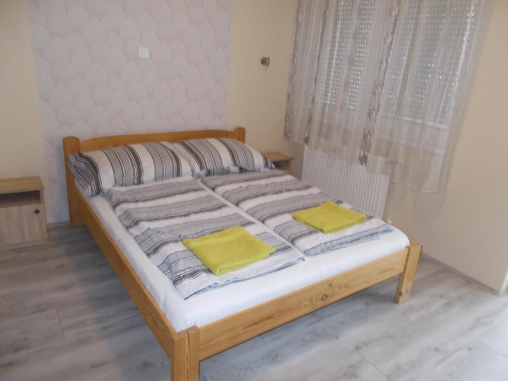 a bed with two yellow pillows on it in a room at Green Szálláshely in Debrecen