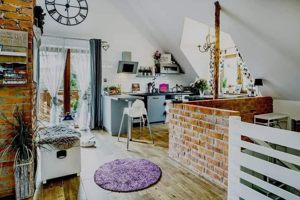 a room with a kitchen with a brick wall at GRAPA LOFT Dom w Górach Apartament Wypoczynek w górach in Lipnica Wielka