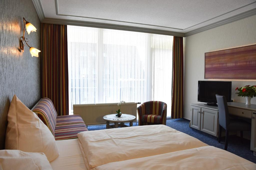 a hotel room with a bed and a television at Hotel Haus Tiefenbach in Bullange