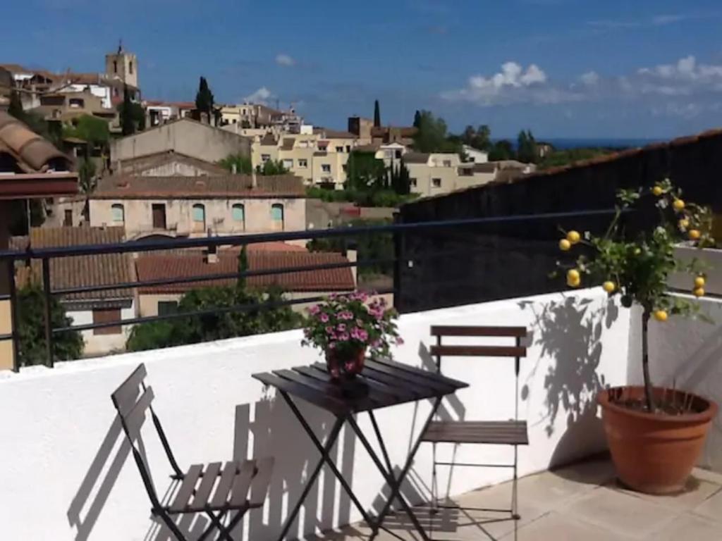 una mesa y sillas en un balcón con vistas en Casa Le Bouganville en Sant Vicenç de Montalt