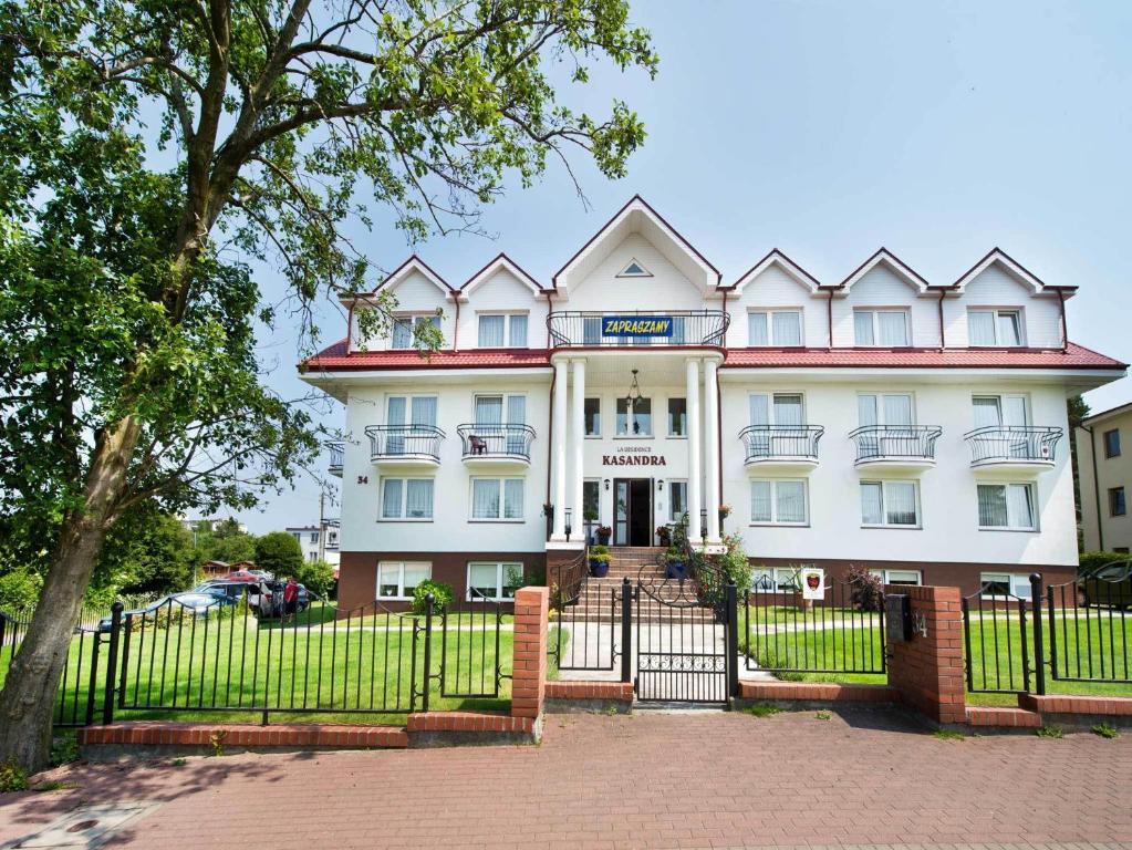 a large white building with a fence in front of it at La Residence Kasandra in Jastrzębia Góra