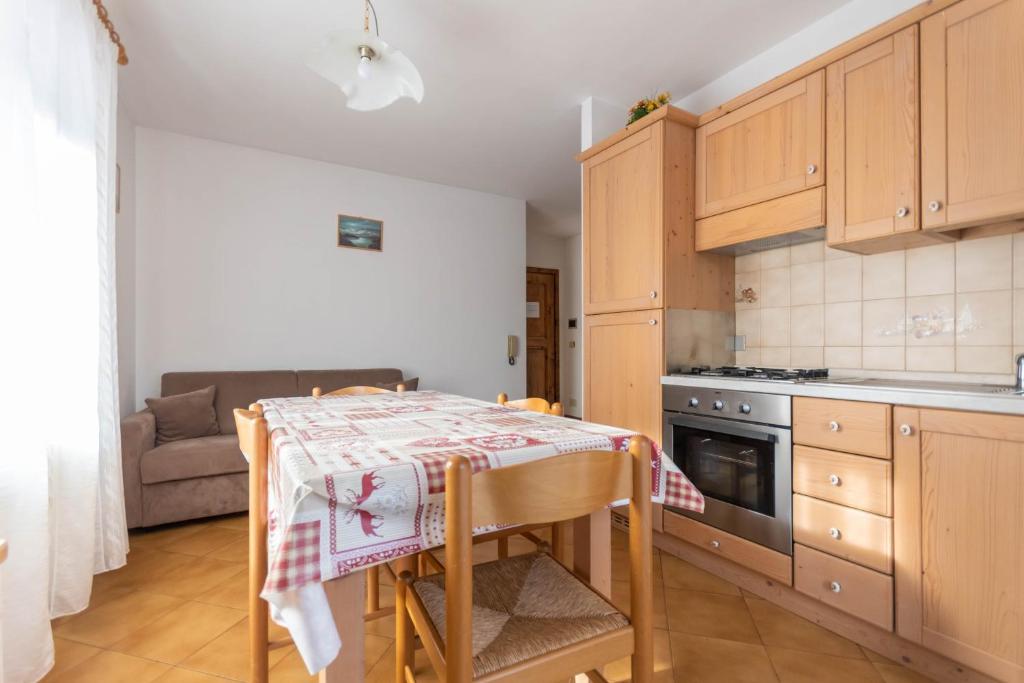 a small kitchen with a table and a couch at Casa Falcade in Falcade