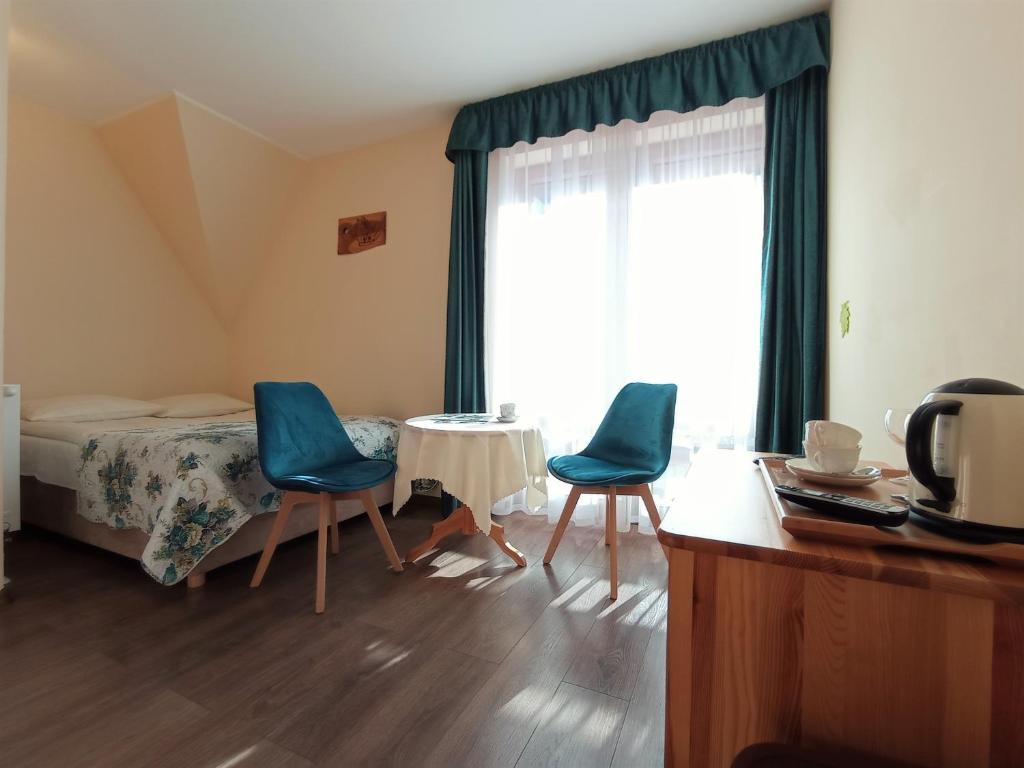 1 dormitorio con 1 cama, 2 sillas y mesa en Wynajem Pokoi Rancho, en Ząb