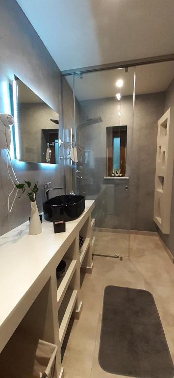 a bathroom with a sink and a mirror at Andros 4 All Seasons Villas & Suites in Andros