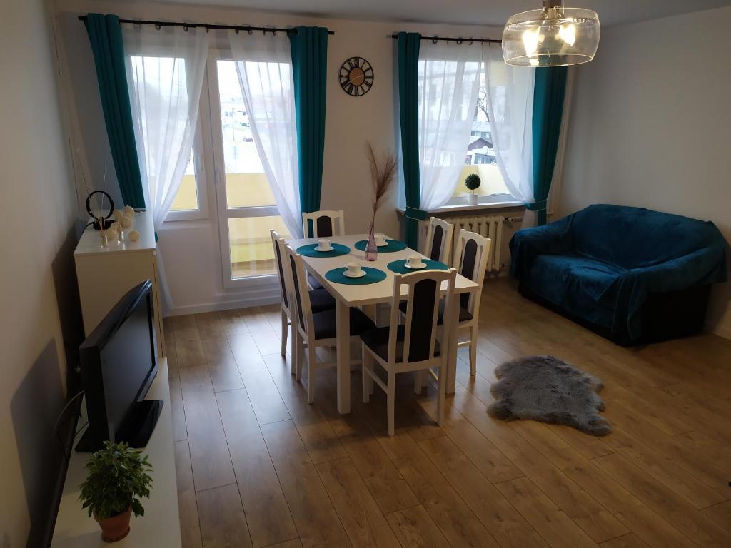 uma sala de estar com uma mesa e um sofá azul em Apartament Góra Szybowcowa em Jelenia Góra