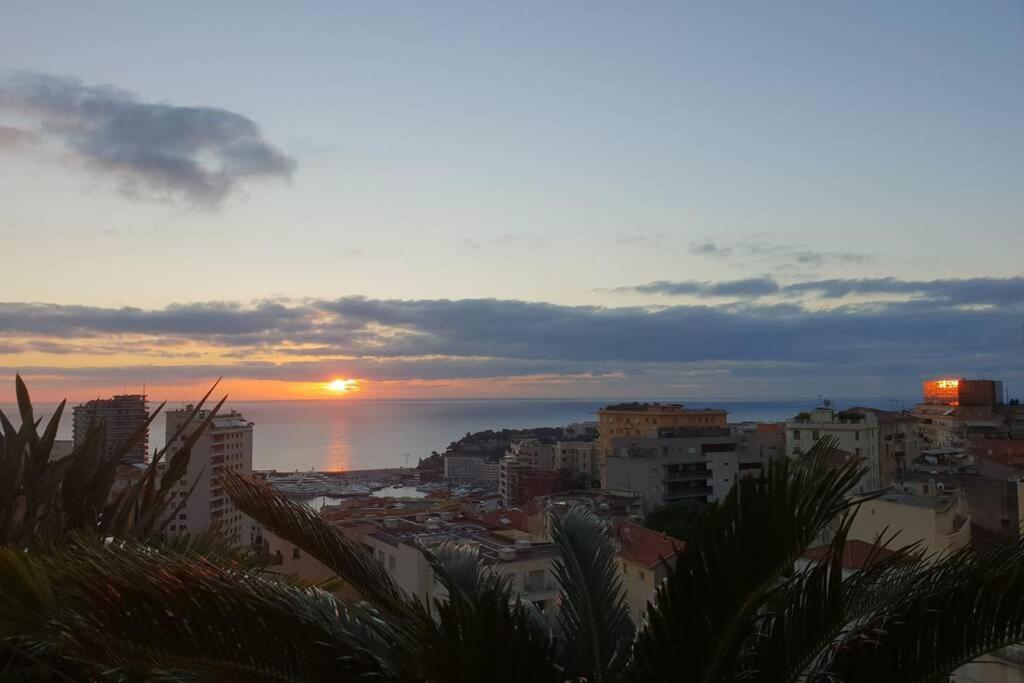 un coucher de soleil sur une ville avec l'océan et les bâtiments dans l'établissement Penthouses+Terrasse 60 m2+Box 2 Vehicules, à Beausoleil