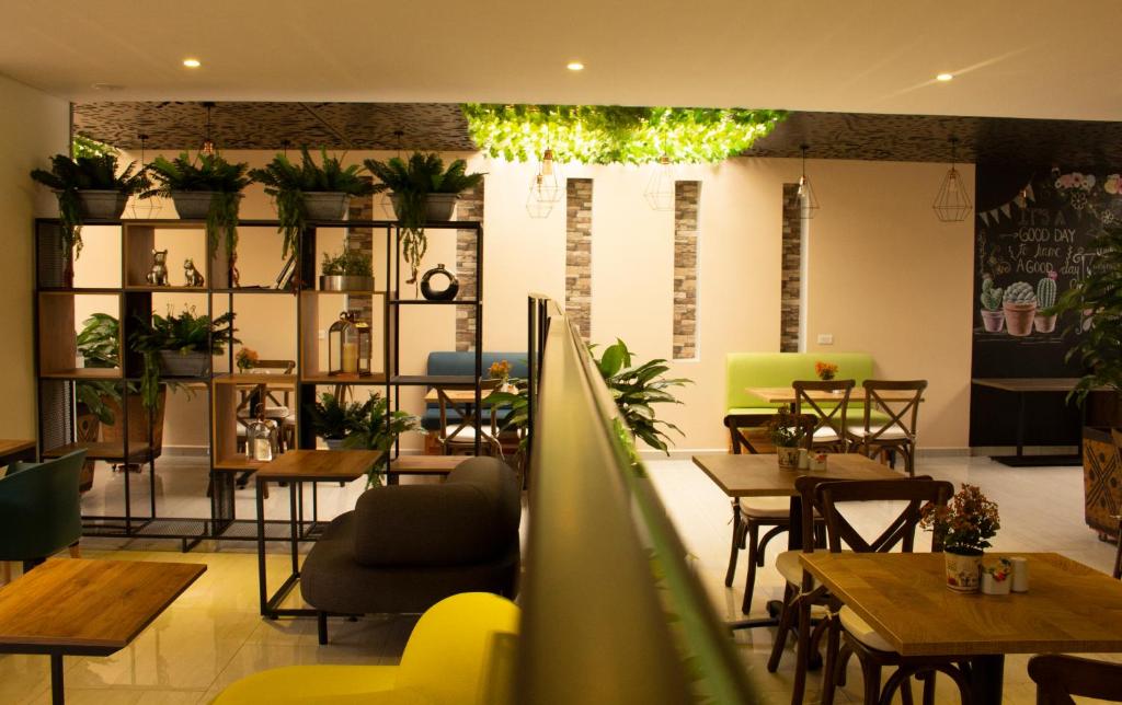 a living room filled with tables and chairs at EcoHub Hotel Medellin in Medellín