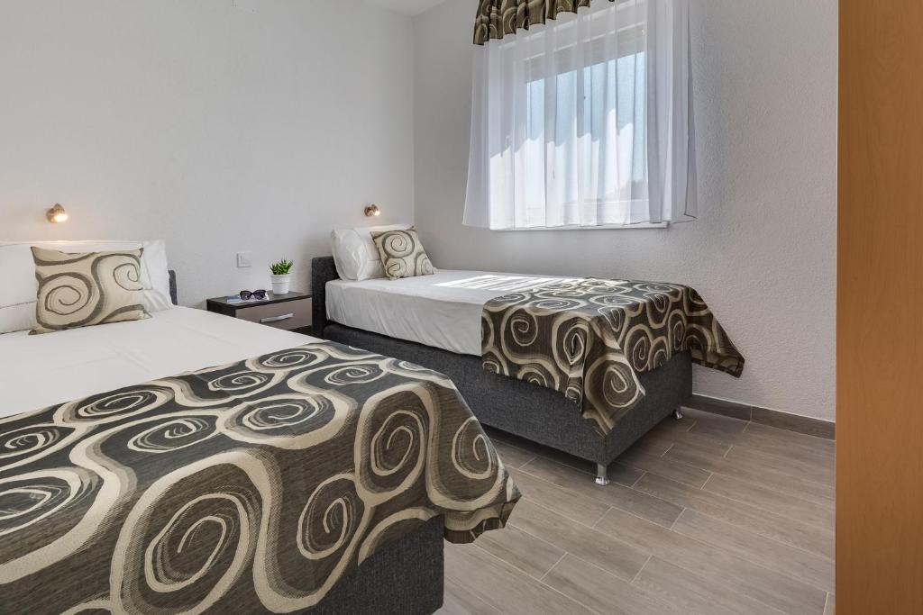 Posteľ alebo postele v izbe v ubytovaní Apartmani Kaštelina