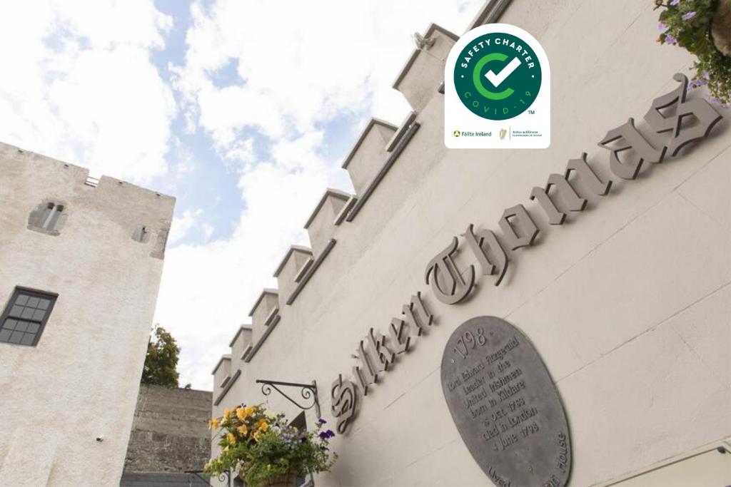 a building with a sign on the side of it at Silken Thomas Accommodation in Kildare