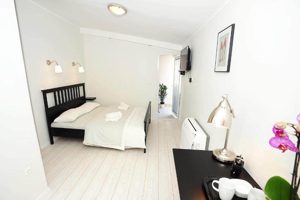 a bedroom with a bed and a desk with a lamp at City Class Accommodation in Zadar