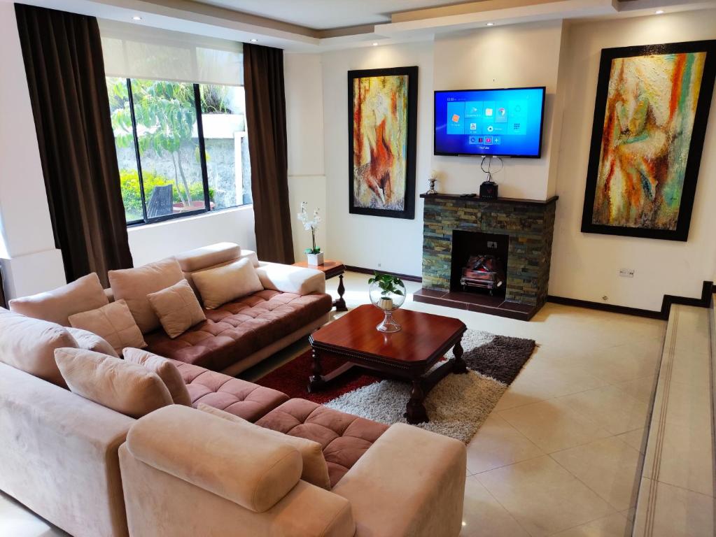 ein Wohnzimmer mit einem Sofa und einem Kamin in der Unterkunft Hospedaje en Quito Norte, Apartamento & Suite independientes in Quito