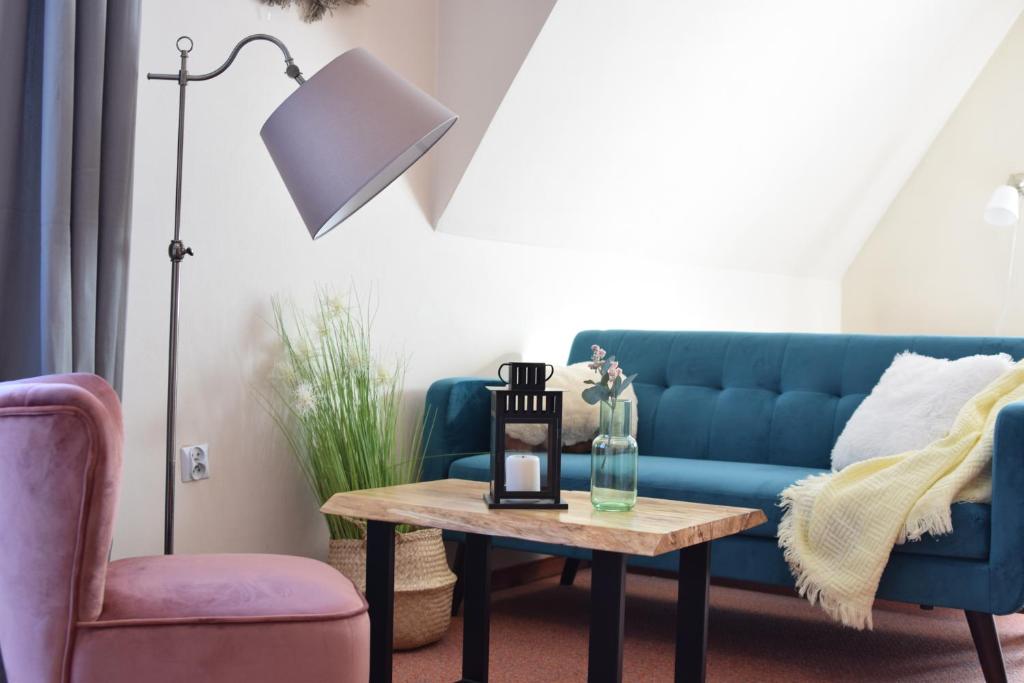 a living room with a blue couch and a table at Willa Magnolia in Bukowina Tatrzańska