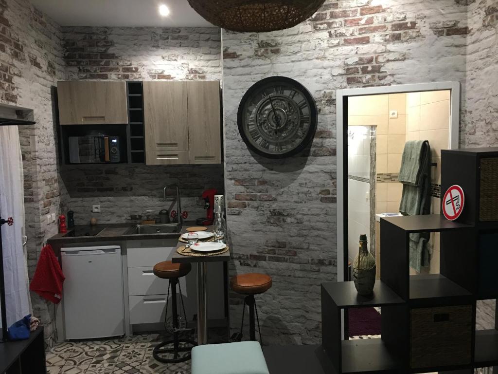 a kitchen with white cabinets and a brick wall at Chambre D'hôte Villa Maurice in Étretat