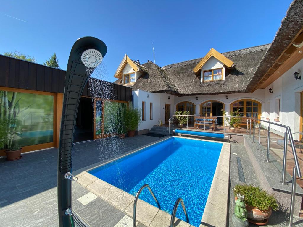 a swimming pool in the backyard of a house at Rigótanya Relax & Wellness Bükfürdő in Bük