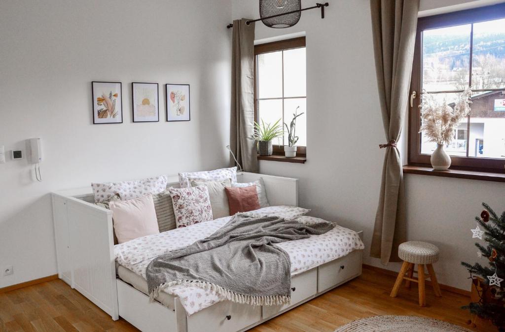 een slaapkamer met een wit bed met kussens en een raam bij Apartmán Efka in Deštné v Orlických horách