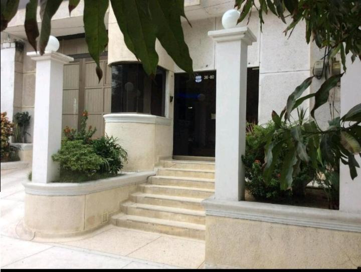 a building with steps leading to a building with a door at Hostal El Recreo in Barranquilla