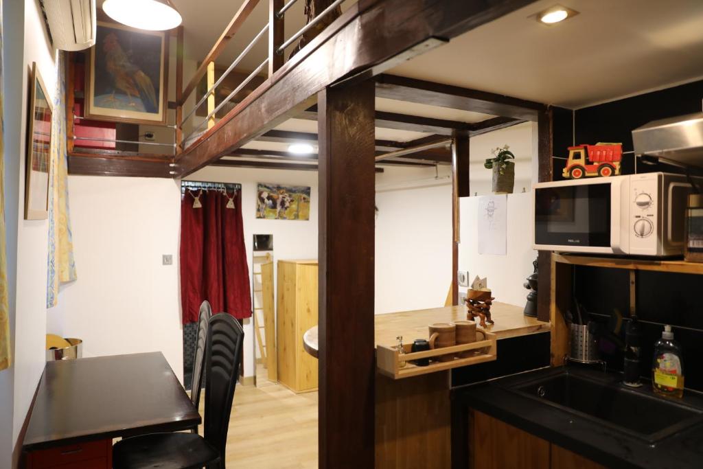 une cuisine avec un évier et un micro-ondes dans l'établissement PARISIEN Espace, à Paris