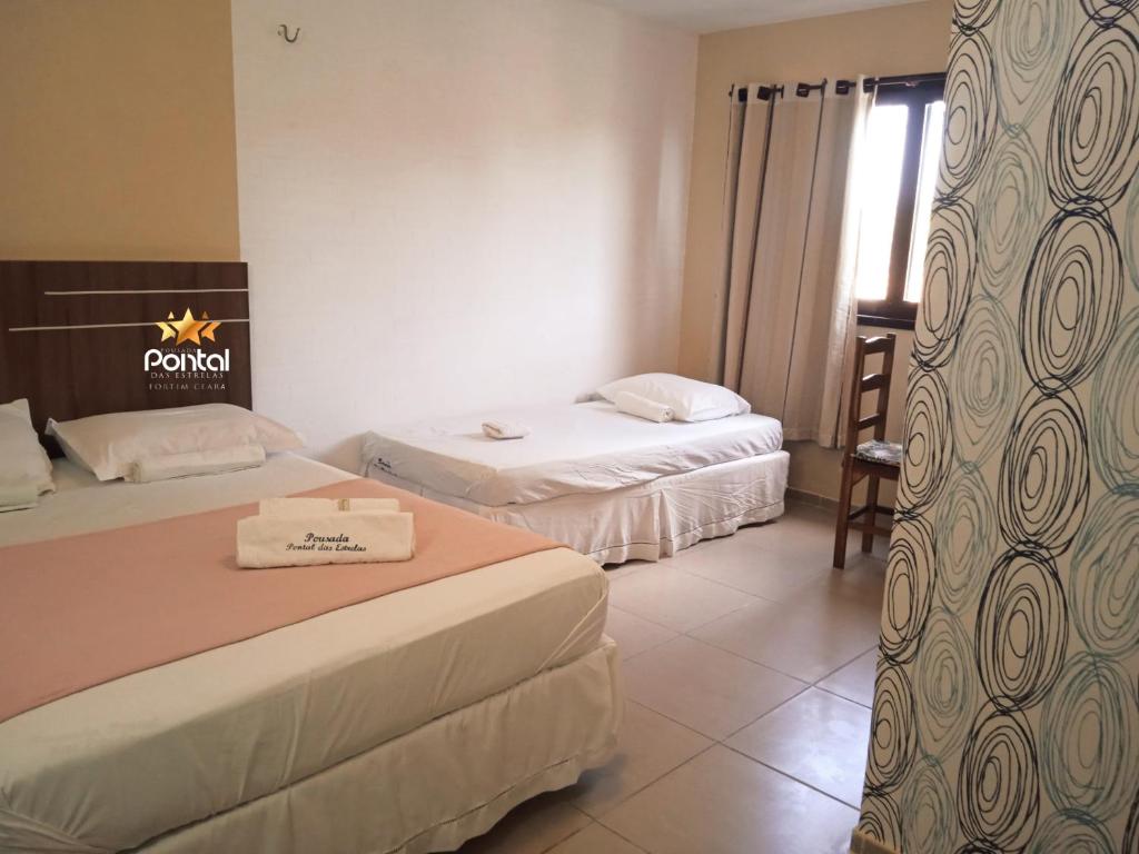 ein Hotelzimmer mit 2 Betten und einem Fenster in der Unterkunft Pousada Pontal das Estrelas in Fortim