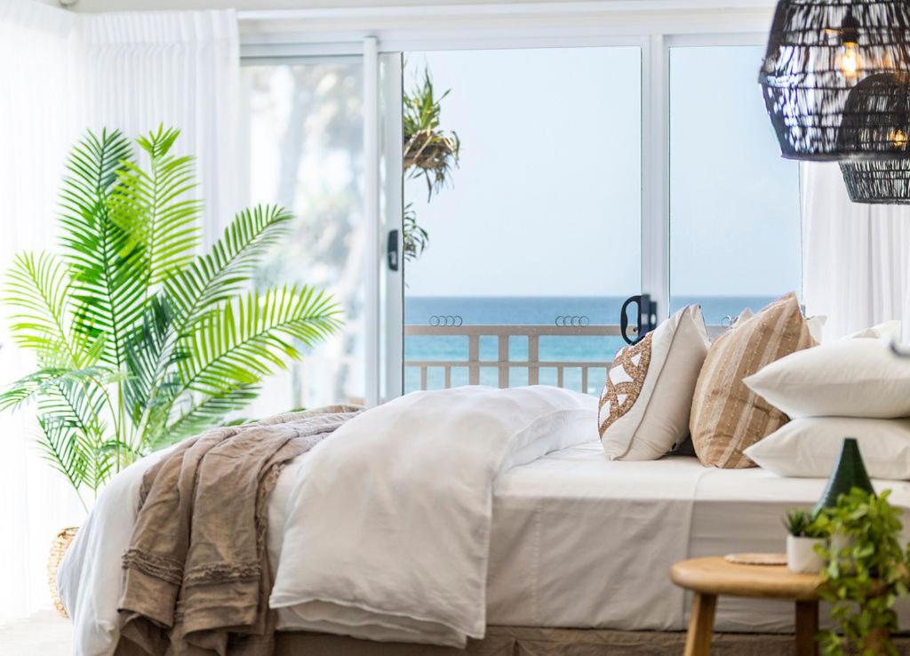 Absolute Beachfront Family Size Home في غولد كوست: غرفة نوم مع سرير وإطلالة على المحيط
