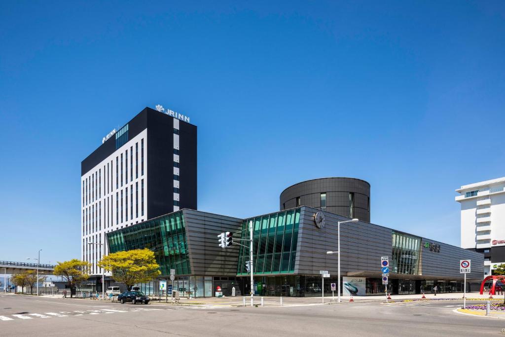 un grande edificio nero con finestre in vetro su una strada di JR Inn Hakodate a Hakodate