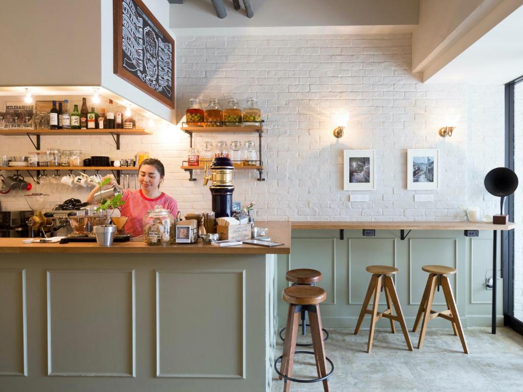 a man sitting at a counter in a kitchen at Hotel Pacific Kanazawa in Kanazawa