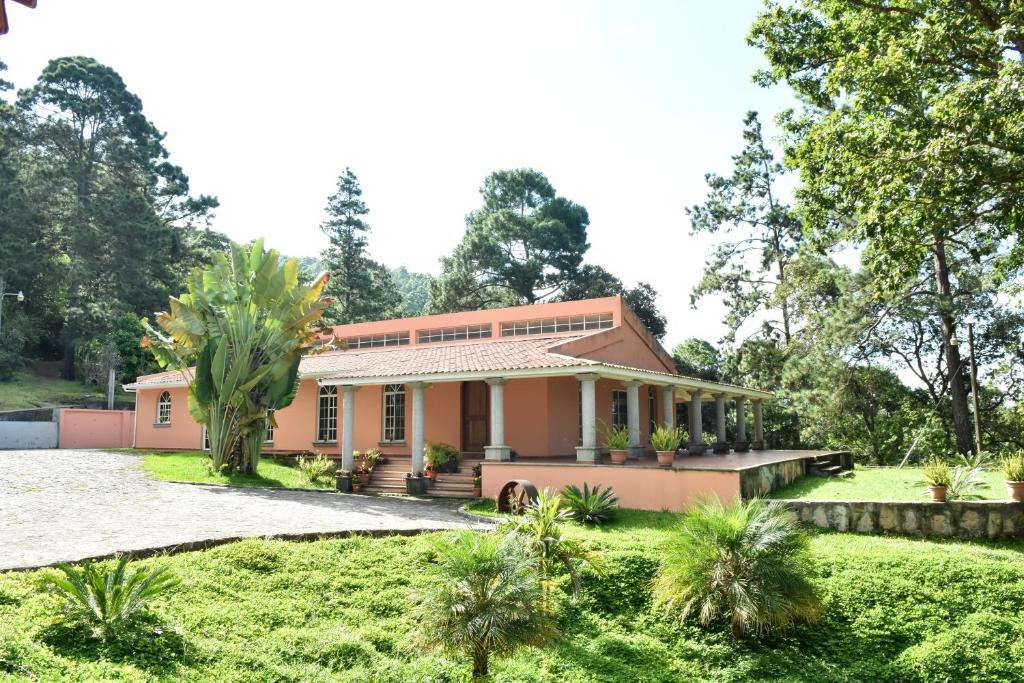 une maison rose avec un jardin devant elle dans l'établissement Uyuca Vista Family Villa, à Tegucigalpa