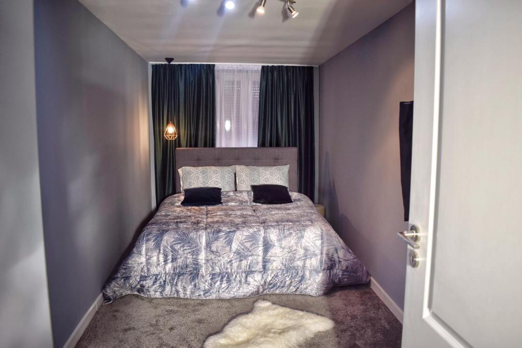 1 dormitorio pequeño con 1 cama con 2 almohadas en VERACI Apartments en Sibiu