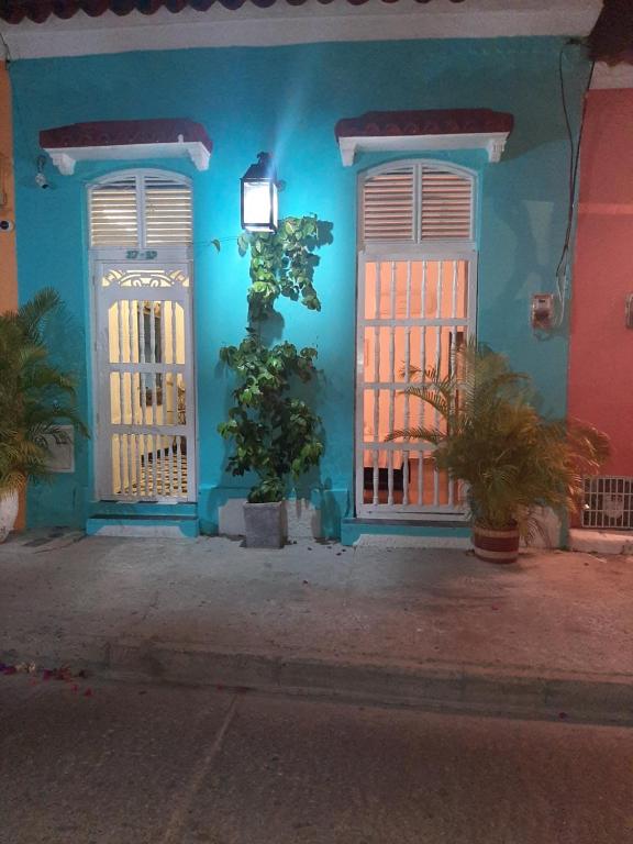 un edificio blu con due porte e un albero davanti di Casa Renacer a Cartagena de Indias