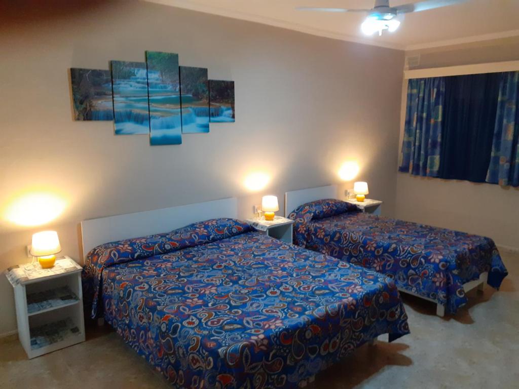 une chambre d'hôtel avec 2 lits et 2 lampes dans l'établissement Black Gold Private Room, à Msida