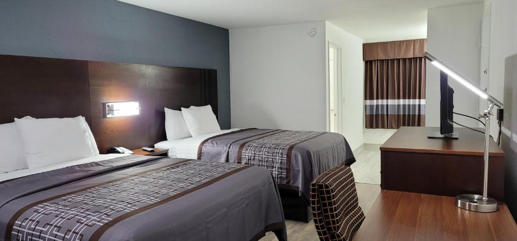 ein Hotelzimmer mit 2 Betten und einem TV in der Unterkunft Key West Inn - Boaz in Boaz