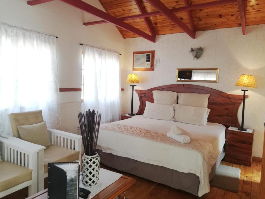 a bedroom with a large bed and two windows at Acacia Bush Lodge in Pietermaritzburg