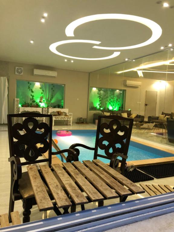 a room with a bench and a swimming pool at شالية فاخر بمسبح خاص بمكة المكرمة in Makkah