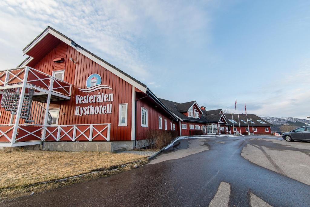 ein rotes Gebäude mit einem Schild an der Seite in der Unterkunft Vesterålen Kysthotell in Stokmarknes