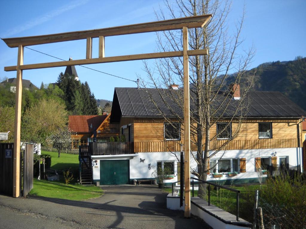 eine große Holzkonstruktion vor einem Haus in der Unterkunft Apartments Am Kirchkogel "Ländliche Entspannung im Herzen der Steiermark" in Pernegg an der Mur