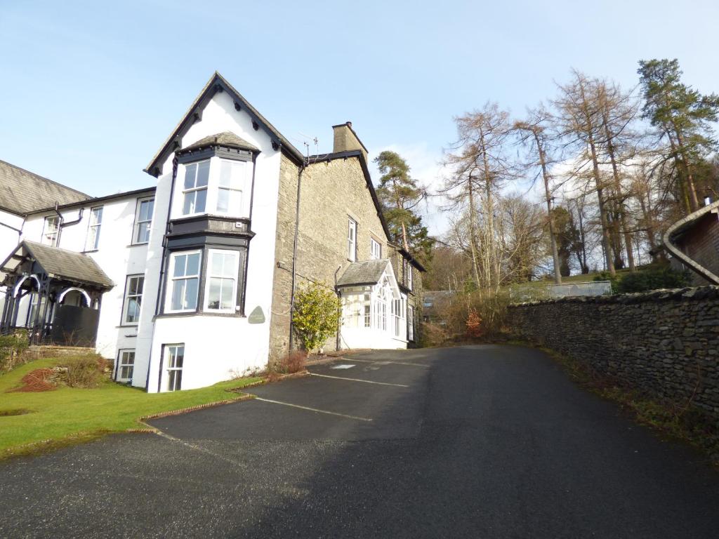 an empty street in front of a white house at Great location, quiet yet 5 mins to Bowness centre with walks from the door and parking in Bowness-on-Windermere