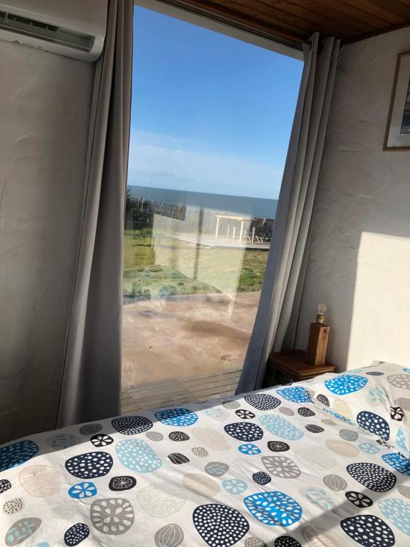 a bedroom with a bed and a large window at La Mer & La Dune in LʼÉpine