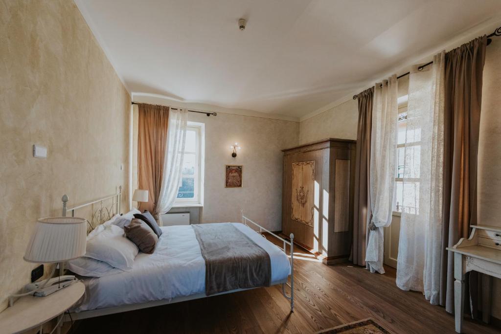 - une chambre avec un lit et une grande fenêtre dans l'établissement Il Castello di Bubbio, à Bubbio