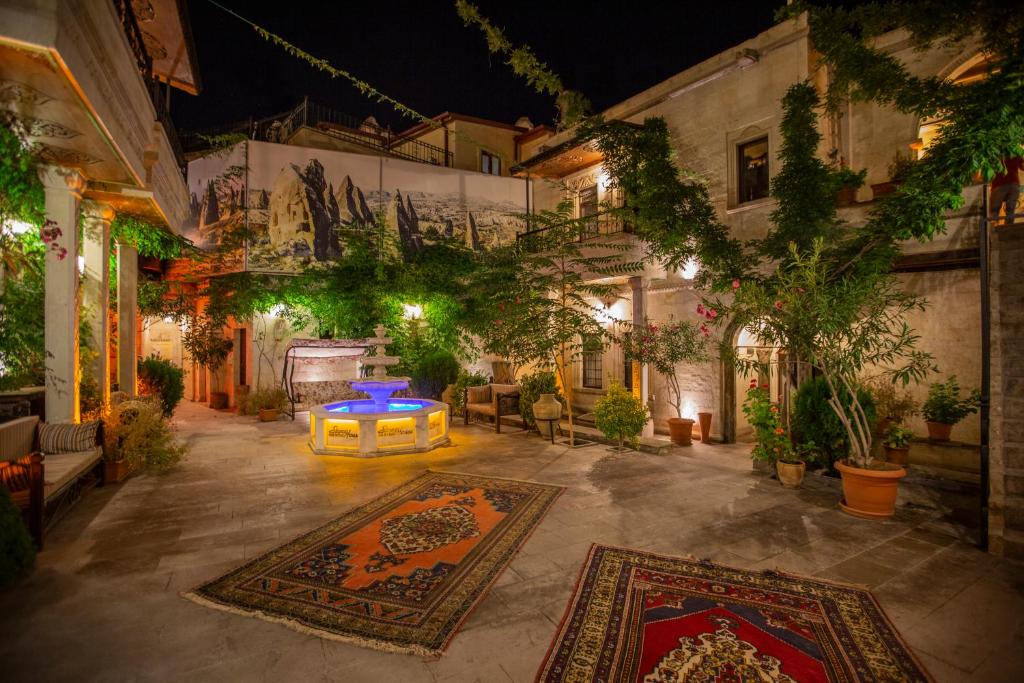 a courtyard with rugs and a table in a building at Stone House Cave Hotel in Göreme