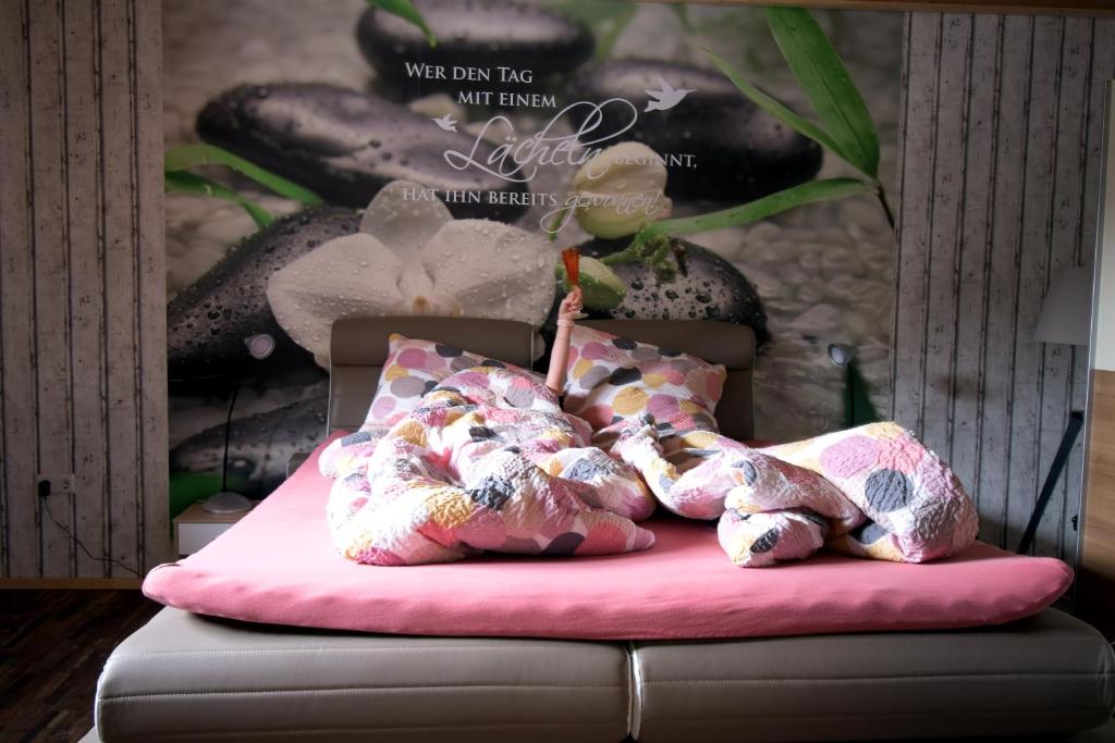 a bed with a pink cushion with stuffed animals on it at Ferienwohnung Haus Willi in Freinsheim