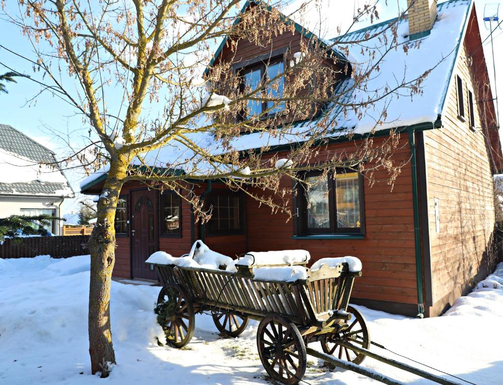 un carruaje en la nieve frente a una casa en Przytulny kąt en Białowieża