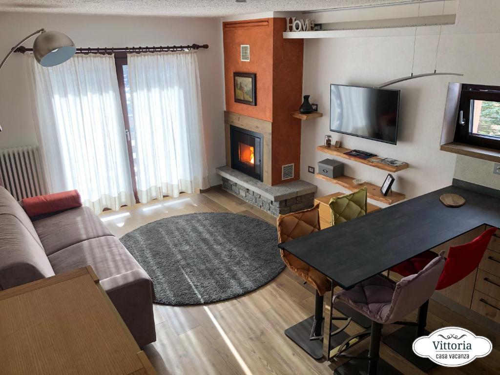 ein Wohnzimmer mit einem Sofa und einem Kamin in der Unterkunft Vittoria Casa Vacanza in Madesimo