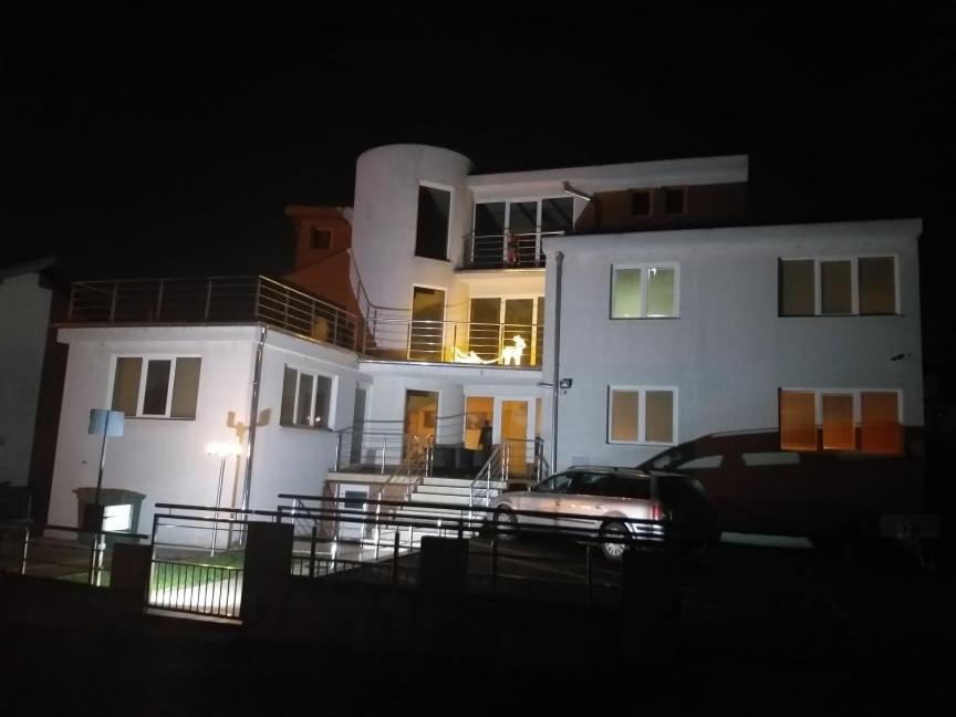 a white house with a car parked in front of it at Apartmani Nikola in Vrnjačka Banja