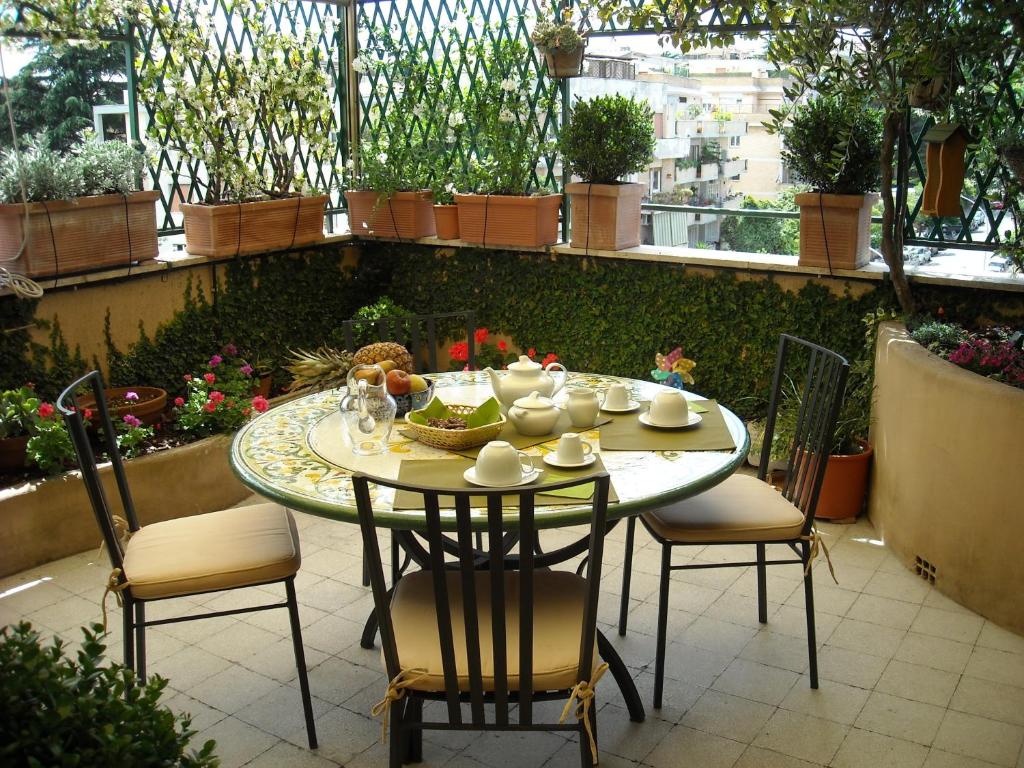 un tavolo e sedie seduti su un patio di Attico Monteverde a Roma