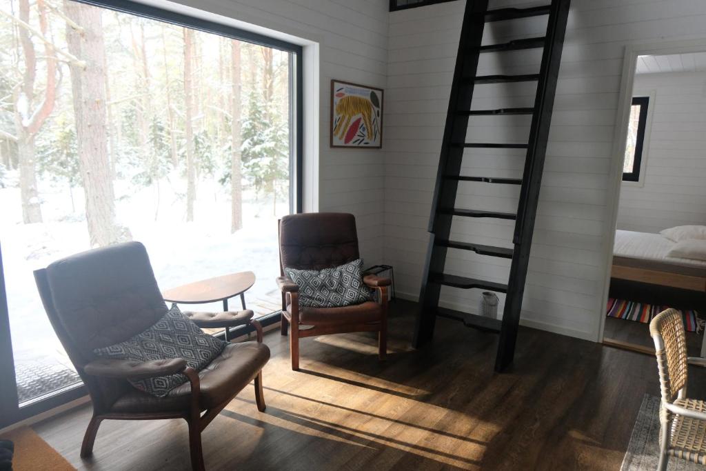 uma sala de estar com 2 cadeiras e uma escada em espiral em Kalana Virve Holiday Villa em Kalana